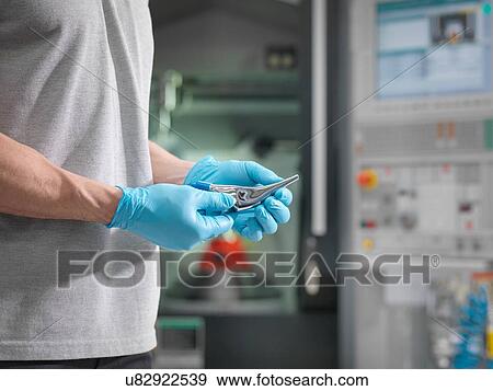 Engineer holding machined artificial hip joint in front of CNC lathe in orthopaedic factory View Large Photo Image Stock Photo - Engineer holding machined artificial hip joint in front of CNC lathe in orthopaedic factory. Fotosearch