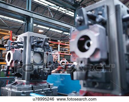 Engineer inspecting parts on automatic lathe in engineering factory View Large Photo Image Stock Photograph - Engineer inspecting parts on automatic lathe in engineering factory. Fotosearch