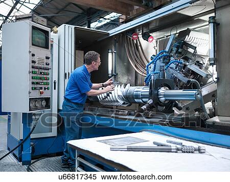 Stock Photography - Engineer inspecting worm drive gear in lathe in engineering factory. Fotosearch