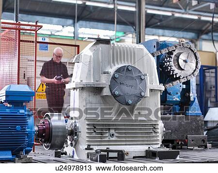 Stock Image - Engineer testing industrial gearbox in engineering factory. Fotosearch