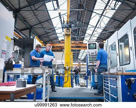 Engineers at lathe workstation in engineering factory View Large Photo Image Stock Image - Engineers at lathe workstation in engineering factory. Fotosearch