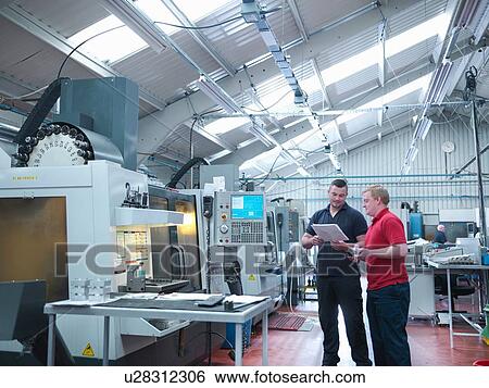 Engineers discussing work in front of CNC machines in engineering factory View Large Photo Image Stock Photograph - Engineers discussing work in front of CNC machines in engineering factory. Fotosearch