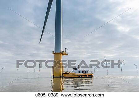 Engineers preparing to climb wind turbine from boat at offshore windfarm View Large Photo Image Stock Photo - Engineers preparing to climb wind turbine from boat at offshore windfarm. Fotosearch