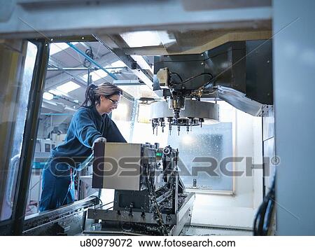 Female apprentice engineer setting up CNC lathe in engineering factory View Large Photo Image Stock Image - Female apprentice engineer setting up CNC lathe in engineering factory. Fotosearch