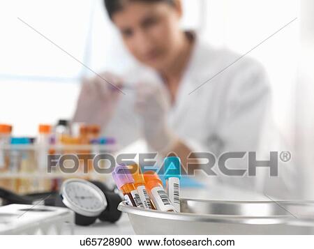 Female doctor inspecting blood sample at desk View Large Photo Image Stock Image - Female doctor inspecting blood sample at desk. Fotosearch