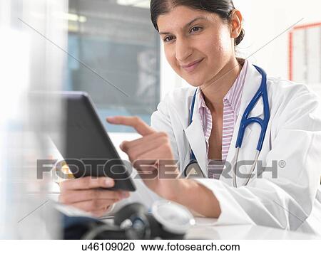 Female doctor using digital tablet touchscreen to update medical records View Large Photo Image Stock Image - Female doctor using digital tablet touchscreen to update medical records. Fotosearch