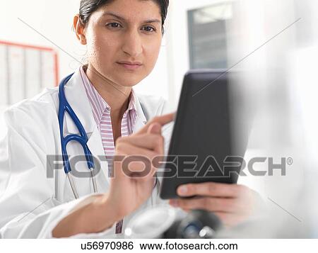 Female doctor using digital tablet touchscreen for medical records View Large Photo Image Stock Photograph - Female doctor using digital tablet touchscreen for medical records. Fotosearch