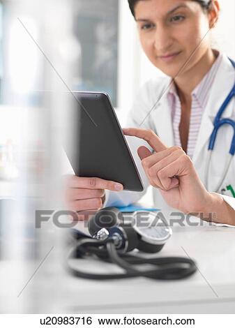 Female doctor using digital tablet to update medical records View Large Photo Image Stock Photograph - Female doctor using digital tablet to update medical records. Fotosearch