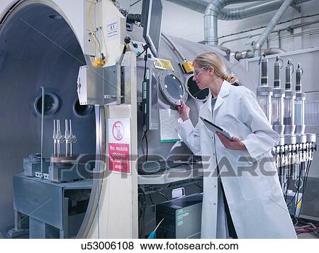 Stock Photo - Female engineer with ceramic coating machine, coating artificial hip joints in orthopaedic factory. Fotosearch