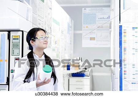 Female scientist holding specimen jar in laboratory View Large Photo Image Stock Photo - Female scientist holding specimen jar in laboratory. Fotosearch