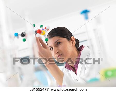 Female scientist in laboratory, viewing molecular model of a chemical formula View Large Photo Image Stock Photo - Female scientist in laboratory, viewing molecular model of a chemical formula. Fotosearch