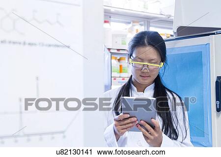 Female scientist reading digital tablet in laboratory View Large Photo Image Stock Image - Female scientist reading digital tablet in laboratory. Fotosearch