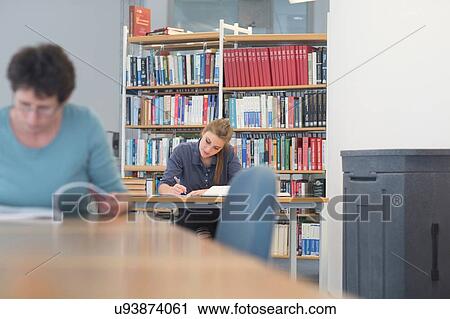 Female students reading textbooks at library desks View Large Photo Image Stock Image - Female students reading textbooks at library desks. Fotosearch