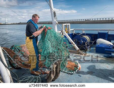 Fisherman preparing fishing net on research ship View Large Photo Image Stock Image - Fisherman preparing fishing net on research ship. Fotosearch