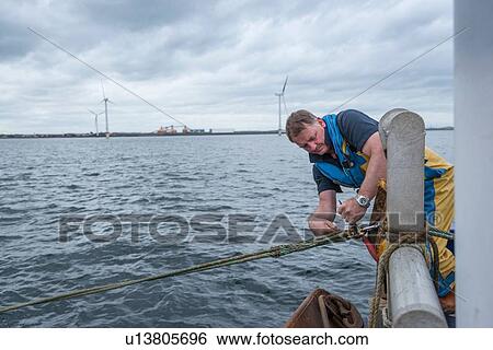 Fisherman tightening trawl line on research ship View Large Photo Image Stock Photograph - Fisherman tightening trawl line on research ship. Fotosearch