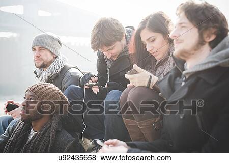 Five young adult friends networking on smartphones View Large Photo Image Stock Photo - Five young adult friends networking on smartphones. Fotosearch