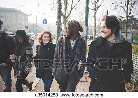 Stock Image - Five young adult friends strolling in city street. Fotosearch