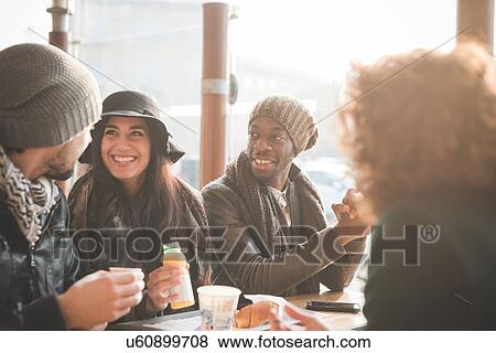 Stock Photo - Four young adult friends chatting at sidewalk cafe. Fotosearch