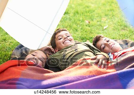 Girl and two brothers lying in garden wrapped in blanket View Large Photo Image Stock Photograph - Girl and two brothers lying in garden wrapped in blanket. Fotosearch
