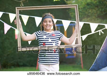 Girl looking through picture frame, looking at camera smiling View Large Photo Image Stock Photograph - Girl looking through picture frame, looking at camera smiling. Fotosearch