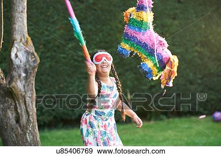 Girl playing pinata in garden View Large Photo Image Stock Photo - Girl playing pinata in garden. Fotosearch