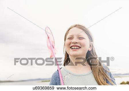 Stock Photo - Girl with fishing net at lakeside, Thingvellir, Iceland. Fotosearch