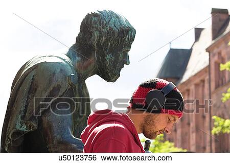 Head and shoulder portrait of mid adult man wearing headphones in front of sculpture, Freiburg, Baden, Germany View Large Photo Image Stock Photograph - Head and shoulder portrait of mid adult man wearing headphones in front of sculpture, Freiburg, Baden, Germany. Fotosearch