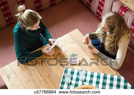 High angle view of two young women playing cards in log cabin View Large Photo Image Picture - High angle view of two young women playing cards in log cabin. Fotosearch
