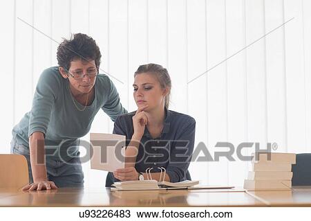 Librarian and female student reading file index card at library desk View Large Photo Image Stock Image - Librarian and female student reading file index card at library desk. Fotosearch