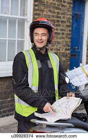 Male motor scooter rider pointing at London street map View Large Photo Image Picture - Male motor scooter rider pointing at London street map. Fotosearch