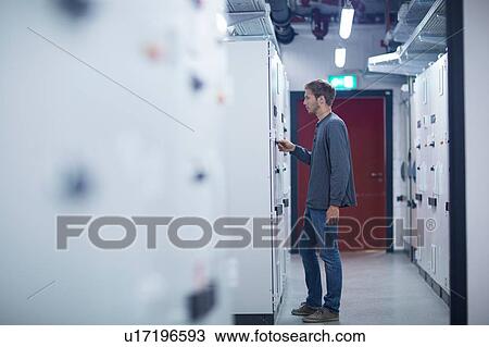 Male technician turning switch on in technical room View Large Photo Image Stock Image - Male technician turning switch on in technical room. Fotosearch