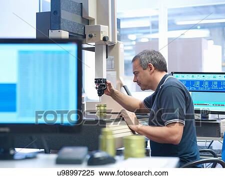 Stock Photography - Male worker inspecting parts in engineering factory. Fotosearch
