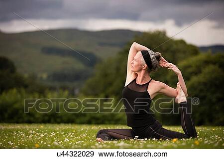 Mature woman doing splits practicing yoga in field View Large Photo Image Stock Photo - Mature woman doing splits practicing yoga in field. Fotosearch