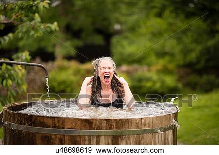 Mature woman in fresh cold water tub at eco retreat View Large Photo Image Stock Photo - Mature woman in fresh cold water tub at eco retreat. Fotosearch