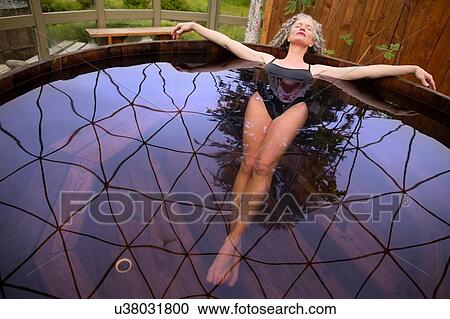 Mature woman lying back in hot tub at eco retreat View Large Photo Image Stock Image - Mature woman lying back in hot tub at eco retreat. Fotosearch