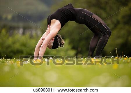 Mature woman practicing yoga backward bends in field View Large Photo Image Stock Image - Mature woman practicing yoga backward bends in field. Fotosearch