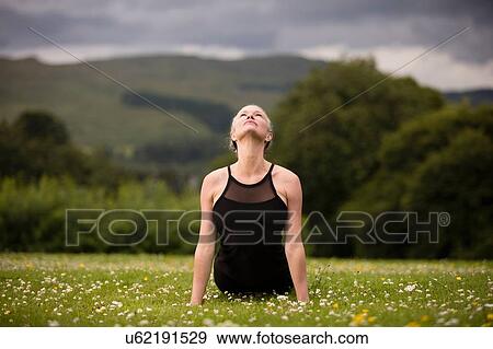 Mature woman practicing yoga cobra position in field View Large Photo Image Stock Photo - Mature woman practicing yoga cobra position in field. Fotosearch