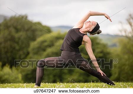 Mature woman practicing yoga pose in field View Large Photo Image Stock Photo - Mature woman practicing yoga pose in field. Fotosearch