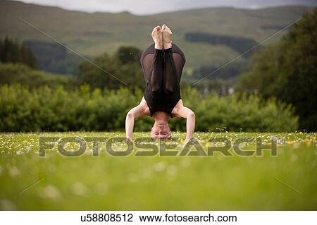 Mature woman practicing yoga standing on head in field View Large Photo Image Stock Image - Mature woman practicing yoga standing on head in field. Fotosearch