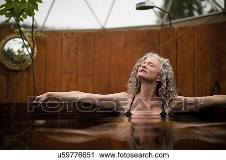 Mature woman relaxing in hot tub at eco retreat View Large Photo Image Stock Image - Mature woman relaxing in hot tub at eco retreat. Fotosearch