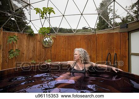 Mature woman relaxing in hot tub at eco retreat View Large Photo Image Stock Image - Mature woman relaxing in hot tub at eco retreat. Fotosearch