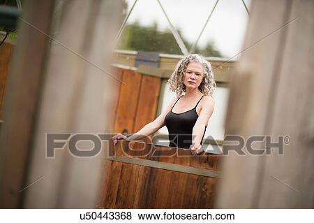 Mature woman standing in hot tub at eco retreat View Large Photo Image Stock Photo - Mature woman standing in hot tub at eco retreat. Fotosearch