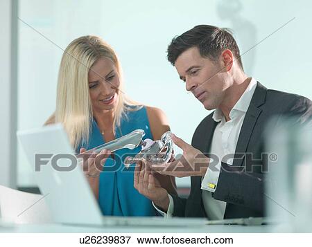 Stock Photo - Medical designers inspecting hip joint model. Fotosearch