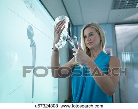 Medical product designer inspecting hip joint model with graphical screen View Large Photo Image Stock Photo - Medical product designer inspecting hip joint model with graphical screen. Fotosearch