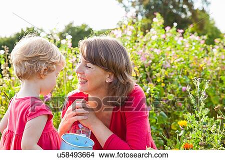 Mid adult mother and toddler daughter in flower field View Large Photo Image Picture - Mid adult mother and toddler daughter in flower field. Fotosearch