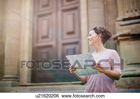 Mid adult woman holding map, looking away, smiling View Large Photo Image Stock Photograph - Mid adult woman holding map, looking away, smiling. Fotosearch