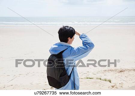 Mid adult woman on beach shielding eyes whilst looking out to sea View Large Photo Image Stock Photography - Mid adult woman on beach shielding eyes whilst looking out to sea. Fotosearch