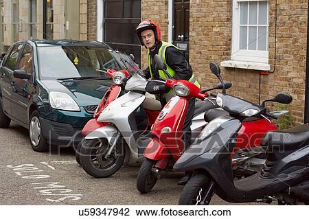 Motor scooter rider parking on street View Large Photo Image Stock Image - Motor scooter rider parking on street. Fotosearch