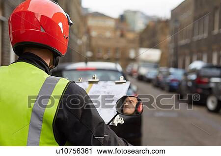 Stock Image - Motor scooter rider, undertaking taxi driver training the knowledge, reflected in wing mirror. Fotosearch