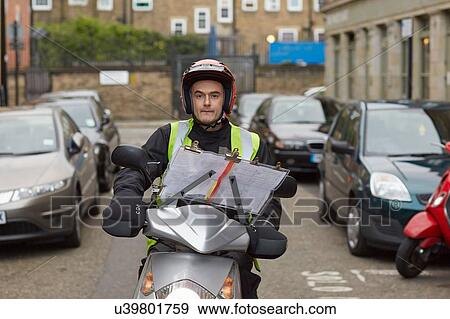 Stock Photo - Motor scooter rider, undertaking taxi driver training the knowledge, on London street. Fotosearch